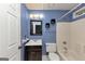 Traditional bathroom features blue walls, vanity with dark cabinets, and a white bathtub and toilet at 916 Forest Pointe, Jonesboro, GA 30238