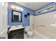 Traditional bathroom features blue walls, vanity with dark cabinets, and a white bathtub and toilet at 916 Forest Pointe, Jonesboro, GA 30238