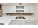 Kitchen featuring stainless steel sink, white cabinetry, and tiled backsplash at 916 Forest Pointe, Jonesboro, GA 30238