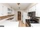 Galley kitchen with white cabinetry, black appliances and tiled backsplash at 916 Forest Pointe, Jonesboro, GA 30238