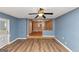 Open living room featuring hardwood floors, blue accent wall, and ceiling fan at 916 Forest Pointe, Jonesboro, GA 30238