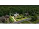 Stunning aerial view of a landscaped home with green lawn and surrounding trees in a serene neighborhood at 115 Blue Grass Way, Oxford, GA 30054