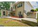 Multi-level home with outdoor living space and landscaping, featuring stairs leading to the backyard at 115 Blue Grass Way, Oxford, GA 30054