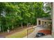 Back of home with a balcony overlooking a lush wooded backyard, creating a private and serene atmosphere at 115 Blue Grass Way, Oxford, GA 30054