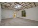 Open basement area with carpeted floor, adjacent to a kitchen and bathroom, full of potential at 115 Blue Grass Way, Oxford, GA 30054