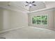 Spacious bedroom with tray ceiling, plush carpet, and a large window offering serene backyard views at 115 Blue Grass Way, Oxford, GA 30054