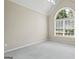 Bright bedroom featuring a vaulted ceiling, large window, and neutral carpet at 115 Blue Grass Way, Oxford, GA 30054