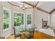 Charming breakfast nook featuring a glass table, chairs, and large windows overlooking the backyard at 115 Blue Grass Way, Oxford, GA 30054