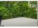 Expansive deck area with black metal railings, offering a serene outdoor space surrounded by lush greenery at 115 Blue Grass Way, Oxford, GA 30054