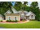 Charming single-story home with stone and stucco accents, manicured landscaping, and a welcoming front entrance at 115 Blue Grass Way, Oxford, GA 30054