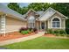 Charming single-story home featuring a stone facade, manicured landscaping, and an inviting entrance at 115 Blue Grass Way, Oxford, GA 30054
