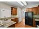 Well-equipped kitchen with granite countertops, wooden cabinets, and black appliances at 115 Blue Grass Way, Oxford, GA 30054