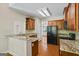 Well-equipped kitchen with granite countertops, wooden cabinets, and black appliances at 115 Blue Grass Way, Oxford, GA 30054