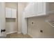 Functional laundry room with white cabinets, tile flooring, and ample storage space at 115 Blue Grass Way, Oxford, GA 30054