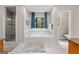 Bright bathroom featuring a large tub with decorative window and separate shower at 401 Riverwalk, Mcdonough, GA 30252