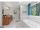 Bright bathroom featuring a large tub with decorative window, separate shower and vanity at 401 Riverwalk, Mcdonough, GA 30252