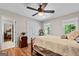 Bedroom features hardwood floors, ceiling fan, closet, large windows and view to an ensuite at 401 Riverwalk, Mcdonough, GA 30252