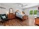 Cozy bedroom with hardwood floors, classic furnishings, and a rocking chair by the window at 401 Riverwalk, Mcdonough, GA 30252