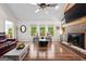 Bright living room with hardwood floors, a brick fireplace, and backyard view at 401 Riverwalk, Mcdonough, GA 30252