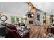 Open living room featuring a brick fireplace, vaulted ceilings, and hardwood floors at 401 Riverwalk, Mcdonough, GA 30252