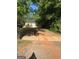 Cozy single-story home with yellow siding, set amongst mature trees and a brick-paved driveway at 908 Emory St, Oxford, GA 30054