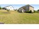 Spacious backyard with lush lawn and brick detailing, perfect for outdoor enjoyment at 1516 Winward Dr, Locust Grove, GA 30248