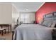 Bedroom features gray furniture, red accent wall, desk, seating area, and carpet flooring at 1516 Winward Dr, Locust Grove, GA 30248