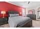 Bedroom features a bed, gray furniture, and a red accent wall at 1516 Winward Dr, Locust Grove, GA 30248