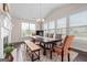 Well-lit dining room featuring a vaulted ceiling, fireplace, hardwood floors, and a large window at 1516 Winward Dr, Locust Grove, GA 30248