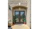 Elegant front door with decorative glass, flanked by potted plants, welcomes you to this beautiful home at 1516 Winward Dr, Locust Grove, GA 30248