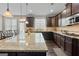 Granite countertops and dark cabinets make this kitchen a dream, with stainless appliances and hardwood floors at 1516 Winward Dr, Locust Grove, GA 30248