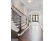 Elegant staircase with hardwood steps and wrought iron railing, leading to the upper level of the home at 1516 Winward Dr, Locust Grove, GA 30248