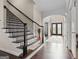 Elegant staircase with hardwood steps and wrought iron railing, leading to the upper level of the home at 1516 Winward Dr, Locust Grove, GA 30248
