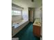Spacious bathroom with a tiled tub, double vanity, and a large window overlooking the exterior at 690 Gateway Ct, Stone Mountain, GA 30087