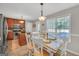 A dining area with white wooden chairs, a view of the kitchen, and bright natural light from large windows at 2006 Carrollton Hwy, Temple, GA 30179