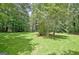 Spacious backyard with lush green grass and mature trees, perfect for outdoor activities at 152 Dana Dr, Fayetteville, GA 30215