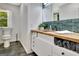 Stylish bathroom with a wood vanity top, green backsplash, and modern fixtures at 152 Dana Dr, Fayetteville, GA 30215