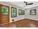 Sunlit bedroom with hardwood floors, wood-trimmed windows and door offering a view of the trees at 152 Dana Dr, Fayetteville, GA 30215