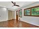 Spacious bedroom featuring hardwood floors, ceiling fan, and three windows for plenty of natural light at 152 Dana Dr, Fayetteville, GA 30215