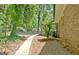 Side exterior of brick home with manicured landscaping, walkway, and lush surrounding greenery at 152 Dana Dr, Fayetteville, GA 30215