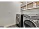 Close-up of the laundry room with modern washer and dryer units, plus storage shelves above at 152 Dana Dr, Fayetteville, GA 30215