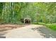 Covered parking and paved driveway leading to home in a wooded area at 152 Dana Dr, Fayetteville, GA 30215