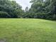 Spacious and well-maintained backyard with lush green grass and mature trees, perfect for outdoor activities at 4884 Maurice Nw Dr, Lilburn, GA 30047