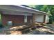 Brick carport featuring a door and ample covered space for vehicle storage with overhead lighting at 1417 Lake Cir, Mableton, GA 30126