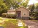Charming home with a lovely front yard and unique purple front door, surrounded by lush greenery at 2134 Main Nw St, Atlanta, GA 30318
