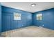 Blue bedroom with paneling detail and two windows providing natural light at 7121 Forest Se Dr, Covington, GA 30014