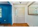 Inviting entryway with hardwood floors, patterned wallpaper, and a classic white door and mirror at 7121 Forest Se Dr, Covington, GA 30014