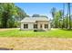 Exterior home view showcasing a white exterior, covered patio and a well manicured backyard at 1547 South Bethany Rd, Locust Grove, GA 30248