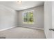 A bright bedroom with carpet and a window looking out to the yard at 1547 South Bethany Rd, Locust Grove, GA 30248