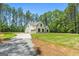 Side view of home with a long driveway leading up to the attached garage, surrounded by a green lawn at 1547 South Bethany Rd, Locust Grove, GA 30248